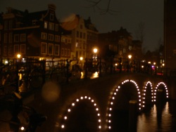 Amsterdam on a rainy night (Photo d'un pont éclairé sur les canaux d'Amsterdam)