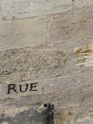 Qui a gravé sur la pierre? (Photo d'une inscription "Rue" gravée dans un mur en pierre dans les rues de Bordeaux)