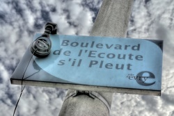 Boulevard de l'Écoute s'il pleut (Photo en HDR d'une plaque du 'Boulevard de l'Écoute s'il pleut' avec un casque posé dessus)